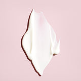 Creamy white texture of Oribe Conditioner for Beautiful Color on a blush pink background