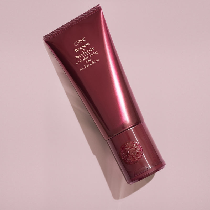 Oribe Conditioner for Beautiful Color tube styled on a blush pink background
