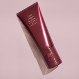 Oribe Conditioner for Beautiful Color tube styled on a blush pink background
