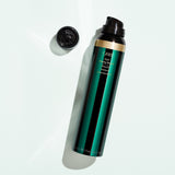 Oribe Curl Shaping Mousse 5.7 oz bottle shown uncapped with the dispensing nozzle on a pale studio background