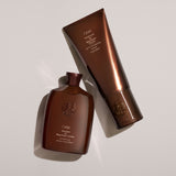 Oribe Shampoo and Conditioner for Magnificent Volume styled on a neutral background