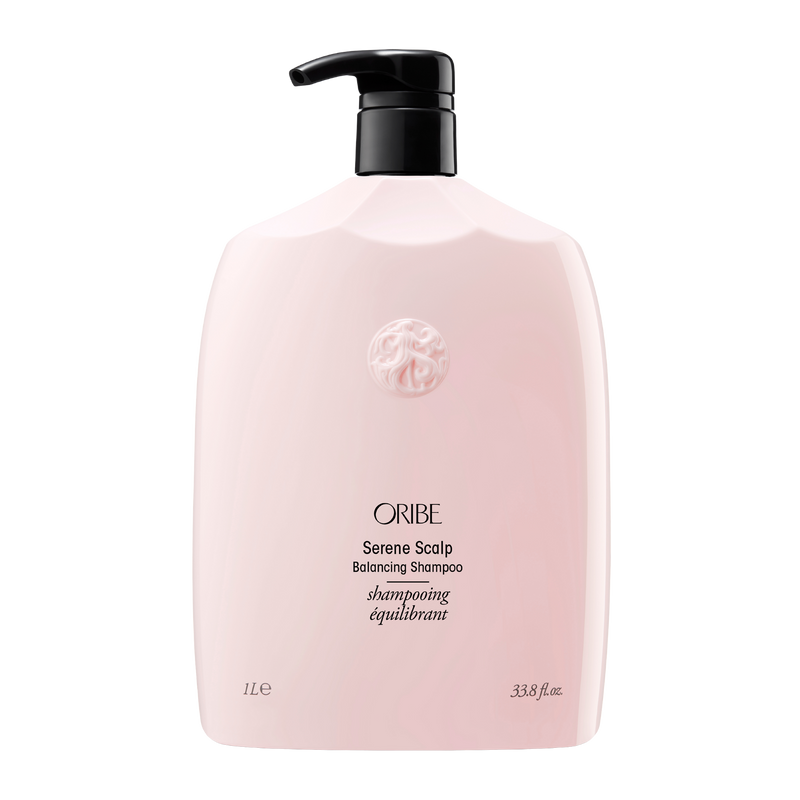Oribe - Serene Scalp shampoo liter sized bottle. Baby pink color bottle with gold letting and black pump top.