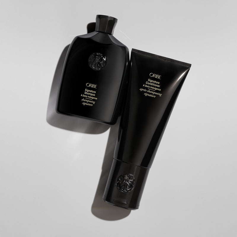 Oribe Signature Shampoo and Conditioner arranged with sculptural shadows