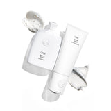 Oribe Silverati Shampoo and Silverati Conditioner styled together with pearlescent shampoo lather and silver conditioning cream on white