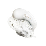 Pearlescent white lather from Oribe Silverati Shampoo with fine foam, translucent bubbles and a soft silvery sheen on white