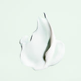 Cream texture of Oribe Styling Butter Curl Enhancing Crème on a pale green background