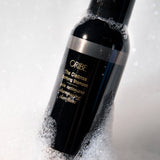 Close-up of Oribe The Cleanse Clarifying Shampoo highlighting its deep cleansing formula that removes buildup while leaving hair soft and balanced.