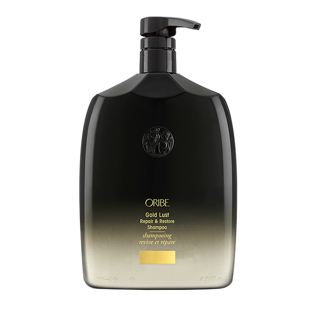 Oribe - GOLD LUST Shampoo liter sized rounded bottle with black to cream ombre and gold lettering. Black top with pump